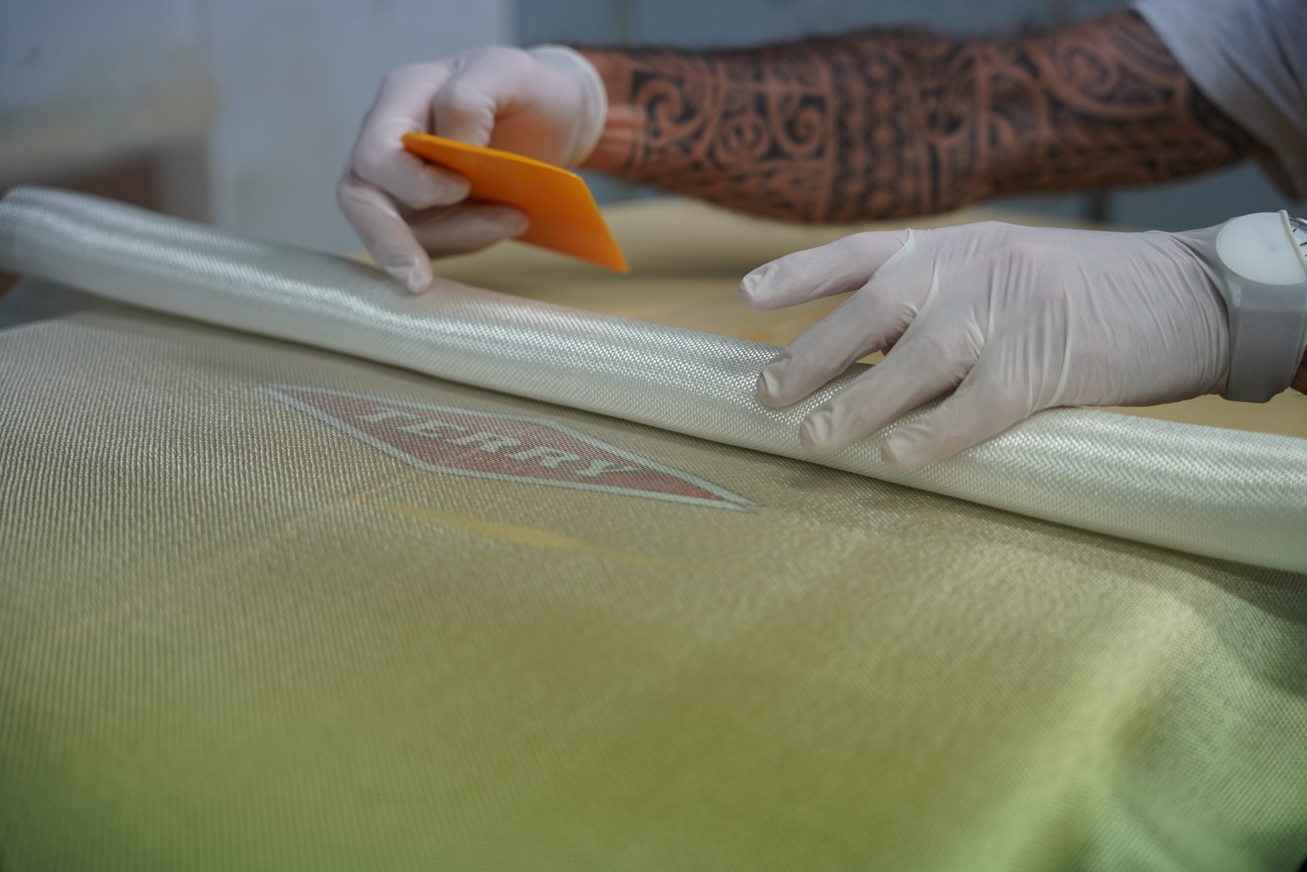 rolling fiber mat over the surfboard and insert sticker or art work below it